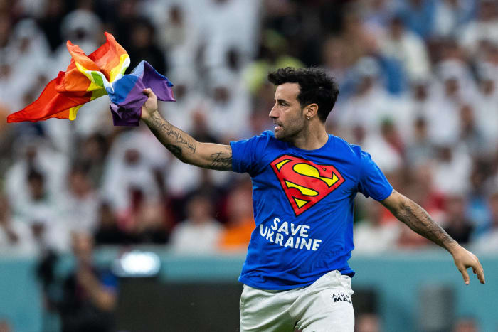 A pitch invader pictured holding a rainbow flag during the World Cup game between Portugal and Uruguay in Qatar